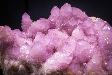 Purple crystals on black background. Amethyst quartz cactus wallpaper. Polished raw gemstone...