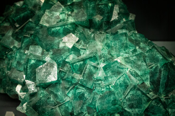 Fluorite stone wallpaper. Textured background of green stone. Crystal gemstone under the lights
