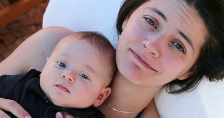 Mother doing sad face holding baby infant casual family moment