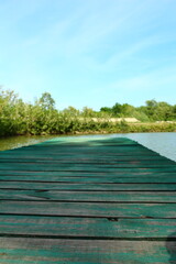 A wooden dock over a body of water with trees in the background