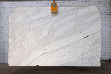 Picture of a white marble slab on a hanger, shot in natural light, a cut of decorative marble in a...