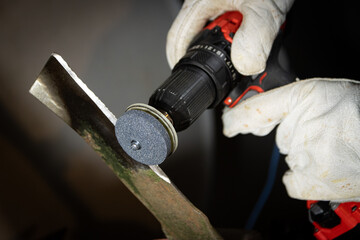Lawnmower blade being sharpened with drill attachment.