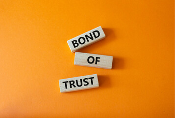 Bond of trust symbol. Wooden blocks with words Bond of trust. Beautiful orange background. Business...