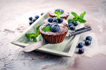 Traditional American oatmeal muffin with blueberries and walnuts served as close-up a wooden baking...