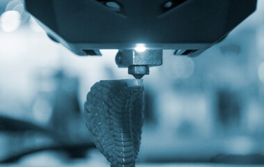 3D printer working close-up. 3D printer prints a model from molten yellow plastic close-up. 3D...
