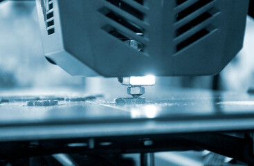3D printer working close-up. 3D printer prints a model from molten yellow plastic close-up. 3D...