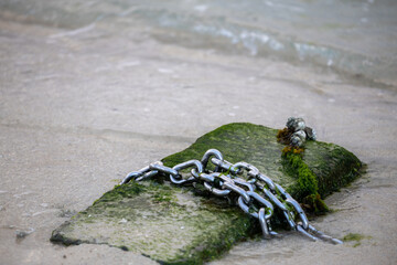 Steel chain on concrete by the sea