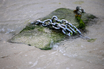 Steel chain on concrete by the sea