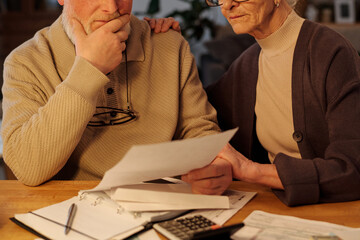 Cropped shot of elderly woman supporting her husband touching his face while both looking at unpaid financial bill sent by post