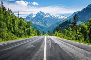 Naklejka premium Empty Highway Through Green Forest and Mountains With Snow Peaks on the Horizon
