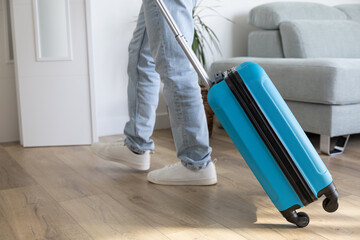 Man leaving home with travel suitcase