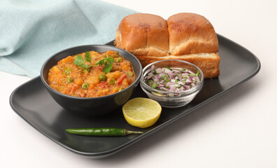 Pav Bhaji is a fast food dish from India, Thick and spicy vegetable curry, fried and served with a soft bread roll/Bun Pav and butter