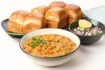 Pav Bhaji is a fast food dish from India, Thick and spicy vegetable curry, fried and served with a soft bread roll/Bun Pav and butter