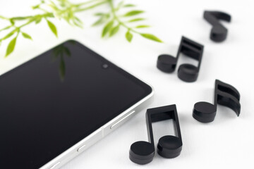 スマートフォンと音符。音楽を聴くイメージ