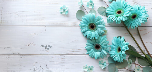 Teal blooms & tender Mother's Day greeting on clean white wood, set against a backdrop of expansive copy space.