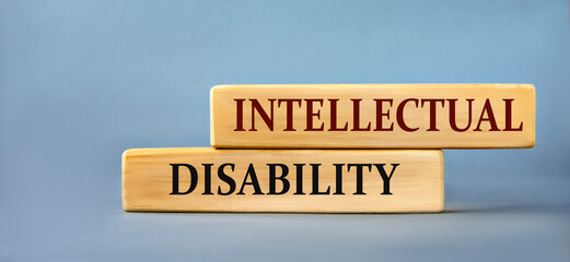 INTELLECTUAL DISABILITY - words on wooden blocks on blue background