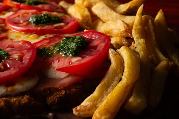 Comida de pizzería y roticería deliciosa y colorida: pizzas, empanadas, pollo al spiedo, canastitas, milanesa, tartas, papas fritas, carne, queso, lechuga, tomate, cebolla, verdeo, aceituna, huevo