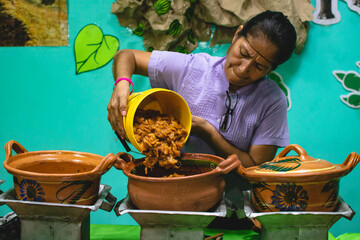 Latin woman serving stews for tacos from her venture