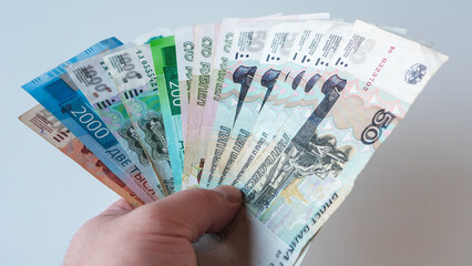 Male hand holding collection of Russian ruble banknotes