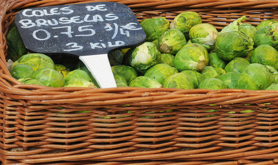 Organic Brussels sprouts in brown willow wicker basket in Spanish market stall. Selective focus