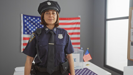 Hispanic policewoman standing confidently in a room with an american flag and ballot box,...