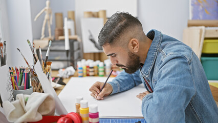 Bearded man drawing in an artistic indoor studio setting, focused and creative