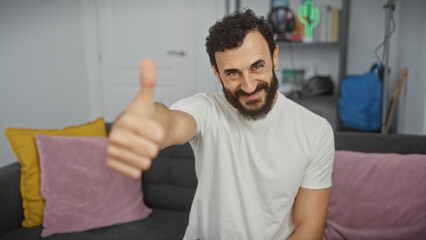 Bearded man in living room giving thumbs up