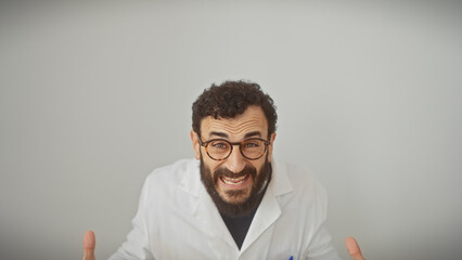 Obraz premium Middle-aged man with beard in lab coat and glasses gestures animatedly against a white background