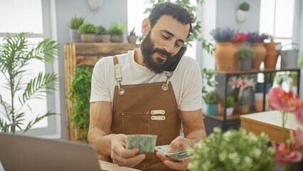 Bearded man counts dirhams indoors at flower shop, portraying business, finance, middle east, and...