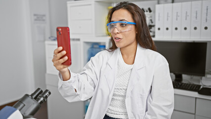 Radiant young hispanic woman scientist, beautifully working on her latest breakthrough in the lab,...