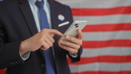 Hispanic businessman with beard using smartphone in office, american flag background, depicting...