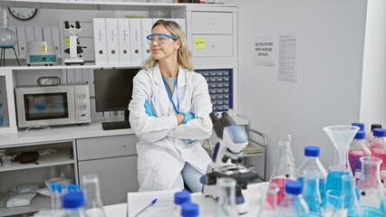A pensive young woman scientist in a lab with crossed arms, surrounded by equipment, portraying...