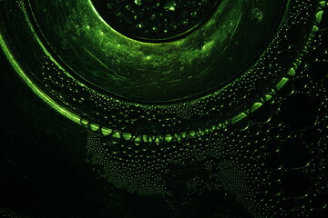 Burbujas de agua color verde sobre la superficie líquida de un cuenco de cristal transparente, con...