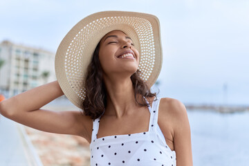 Young african american woman smiling confident wearing summer hat at seaside