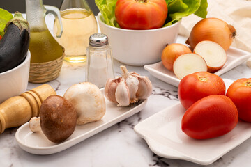 mise en place on table with assorted vegetables in white tableware with oil pepper vinegar and salt...