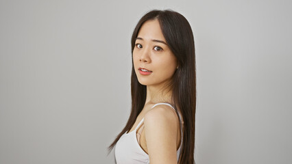 A young chinese woman poses casually against an isolated white background, epitomizing natural...