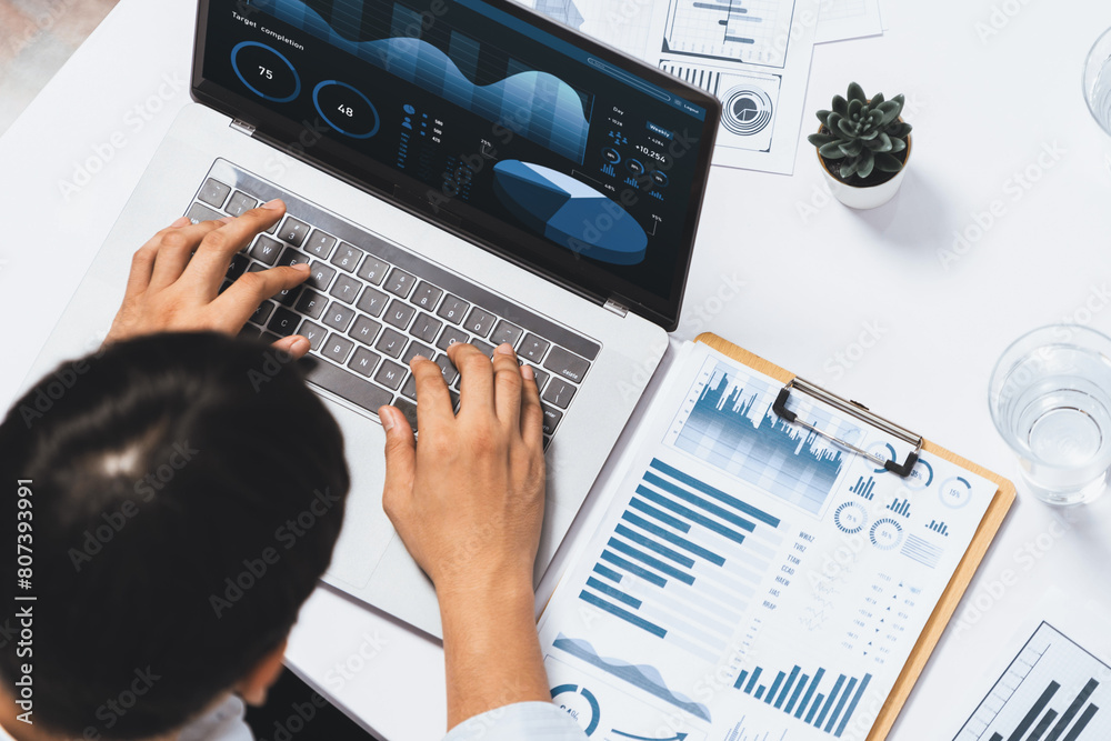 Fototapete Top view data analyst working on laptop on analytic business intelligence or BI dashboard software analyzing financial, trend, marketing database. BI software utilization for business success. Prudent