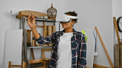 African american woman with curly hair using vr glasses in a creative carpentry workshop indoors.