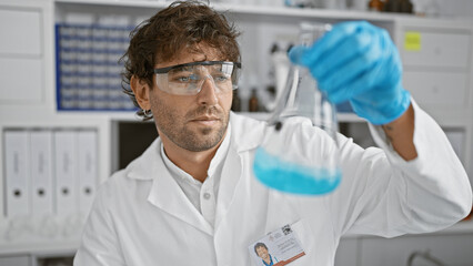Hispanic scientist examines blue liquid in flask at medical laboratory