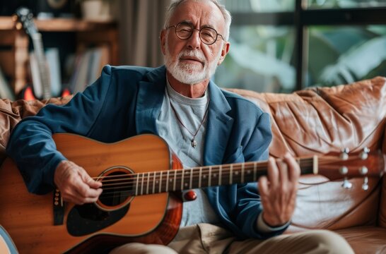 An older man sitting on the couch playing an acoustic guitar