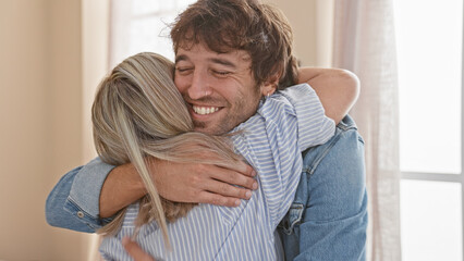 Confident mother and son share a warm, smiling hug indoors, enjoying their love-filled, casual...