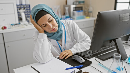 Exhausted hispanic woman doctor resting in a lab, showcasing healthcare burnout and work pressure...