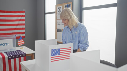 A blonde woman in a striped shirt with a 'voted' sticker at an american polling station.