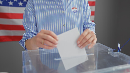 Caucasian woman voting indoors with american flag in background