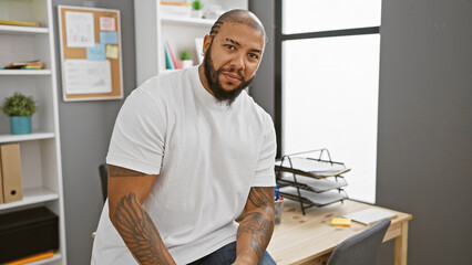 Handsome african american man with beard sitting confidently in a modern office setting