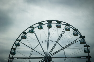 Wide angle views of a Ferris Wheel against a moody, cloudy sky. Vintage feeling, desolation. Nobody...
