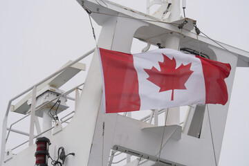 The Canadian national flag waving on top of the BC Ferries Coastal Inspiration vessel on its way to Vancouver Island in British Columbia, Canada