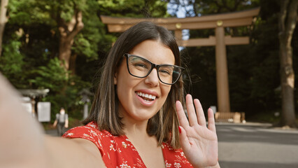 Eye-catching selfie! beautiful hispanic woman waving cheerfully to the camera, taking her picture...