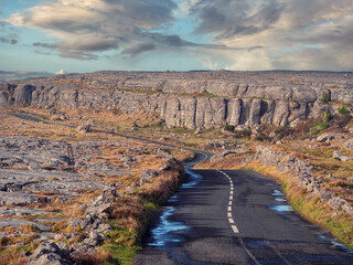Small narrow asphalt road in Burren, county Clare, Ireland. Popular tourist area with amazing rough...