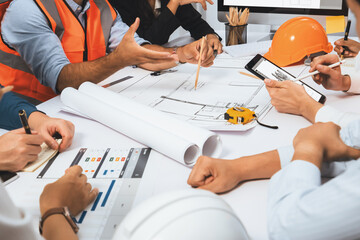 Diverse group of civil engineer and client working together on architectural project, reviewing...